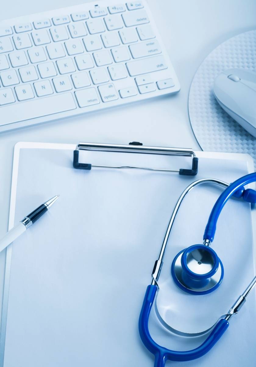 Health Check-Up in Dubai Medical clipboard beside a keyboard and blue stethoscope