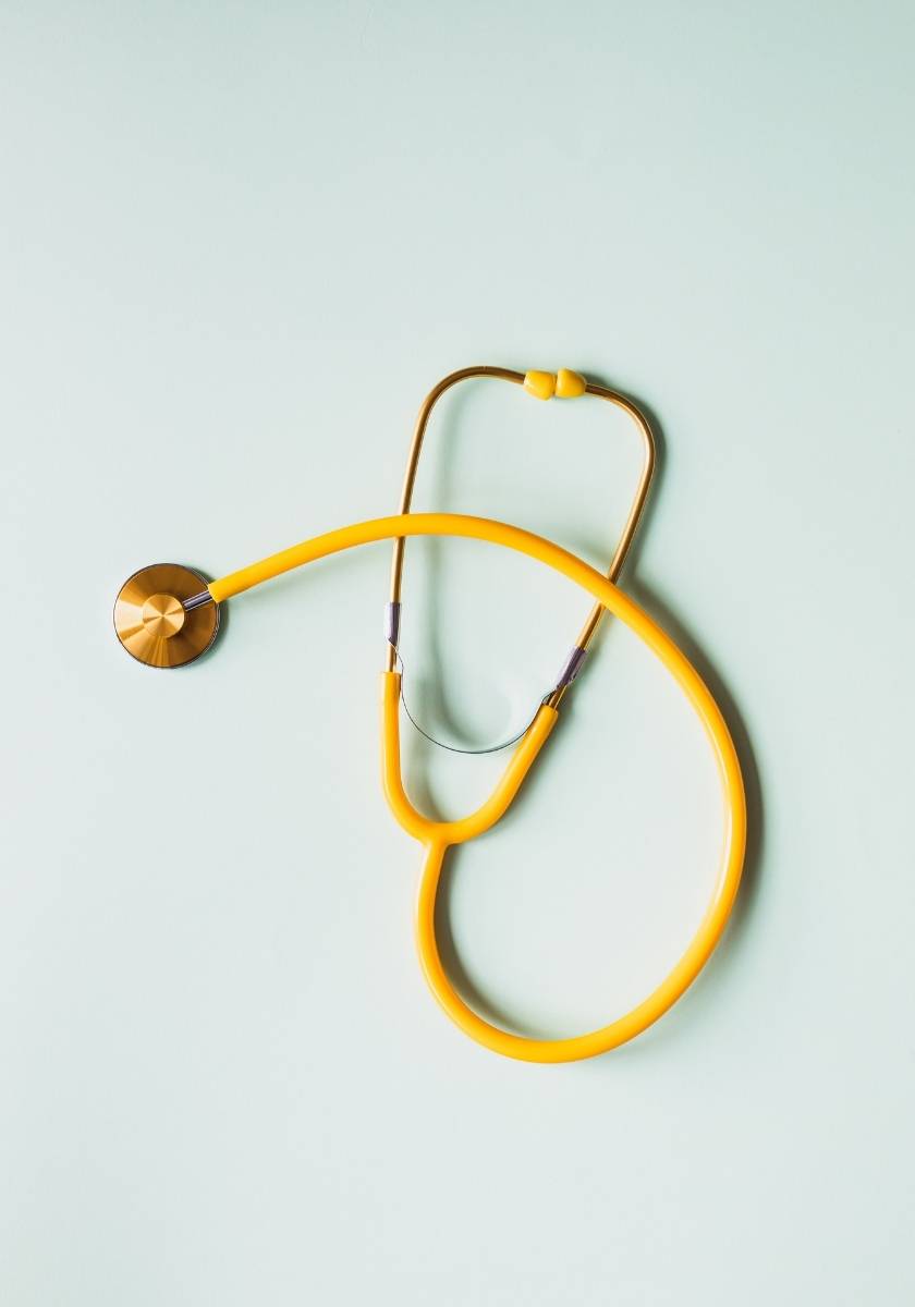 Gold stethoscope placed on a light medical surface